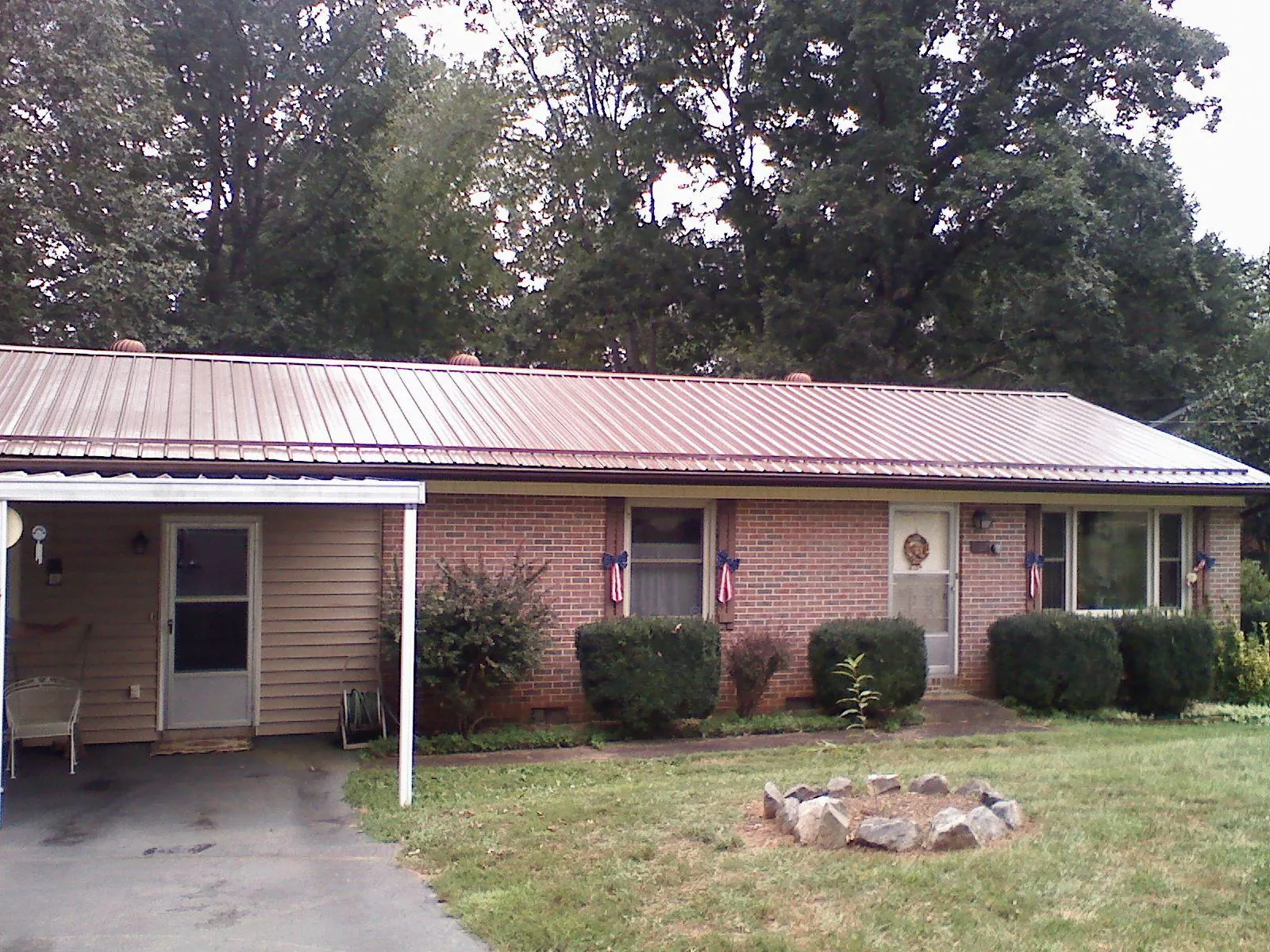 Bronze metal roof and carport on a brick ranch home — Roof Repair work by our crew in Kittery